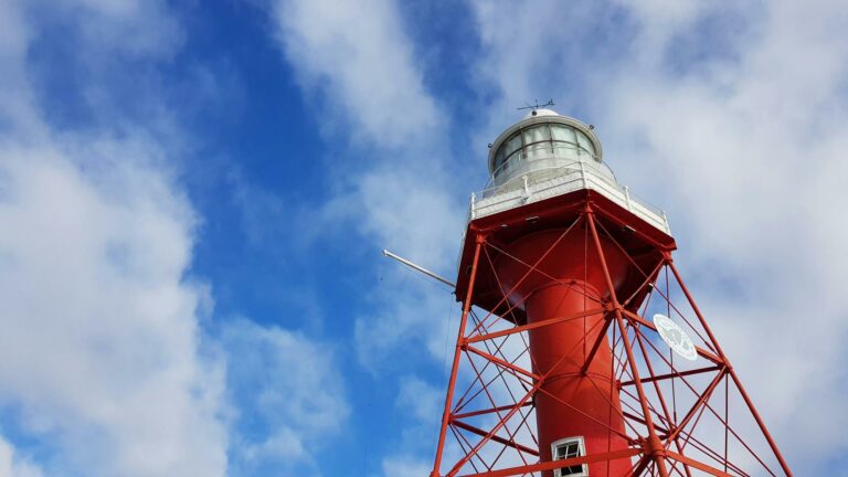 Red lighthouse structure symbolizing local marketing strategies under a vibrant blue sky