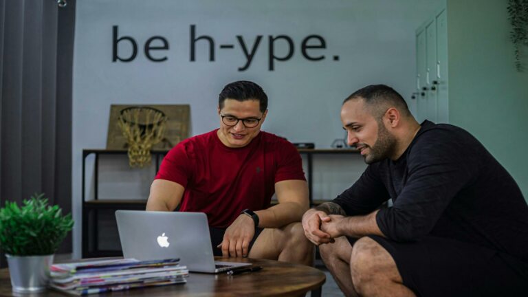 Two individuals collaborating on a laptop to increase website speed in a modern workspace