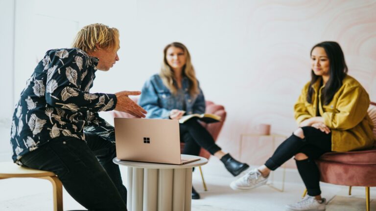 Group of people discussing around a laptop