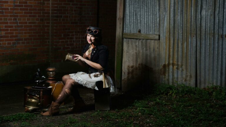 Person in steampunk attire sitting with vintage items