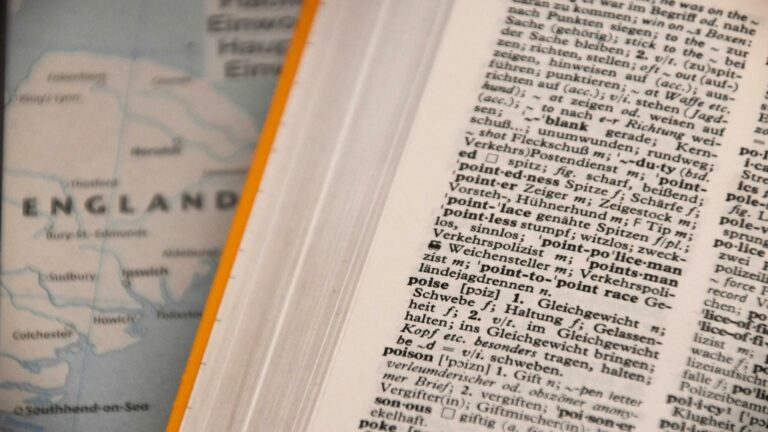 Close-up of a dictionary page with a map of England in the background