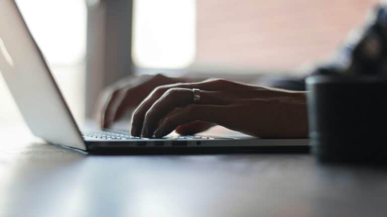 Close-up of hands typing on a laptop keyboard