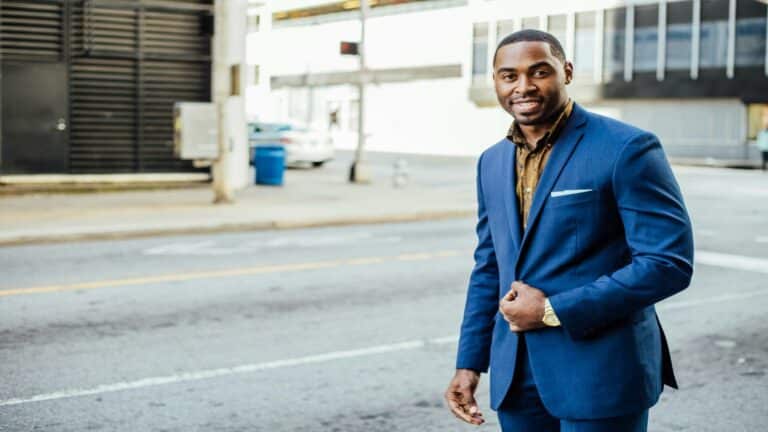 Professional in navy blue suit standing confidently in urban setting