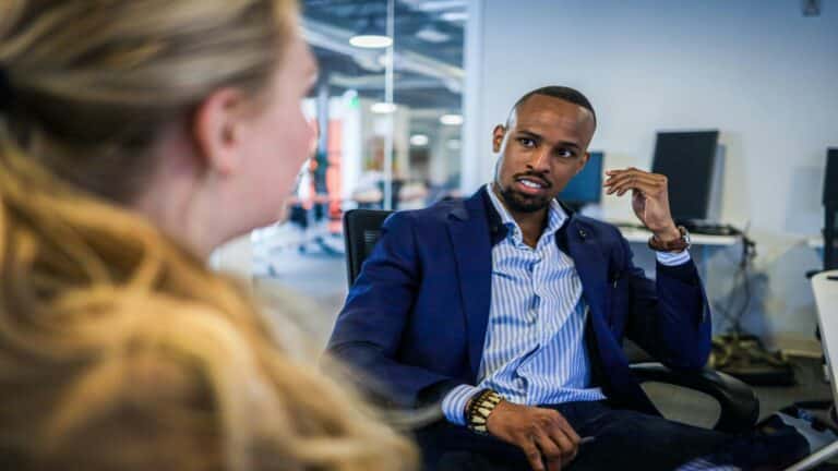 Two professionals discussing strategies for social media optimization in a modern office setting.