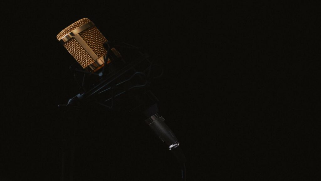 Mobile-friendly design studio equipment with gold-plated condenser microphone against dark background