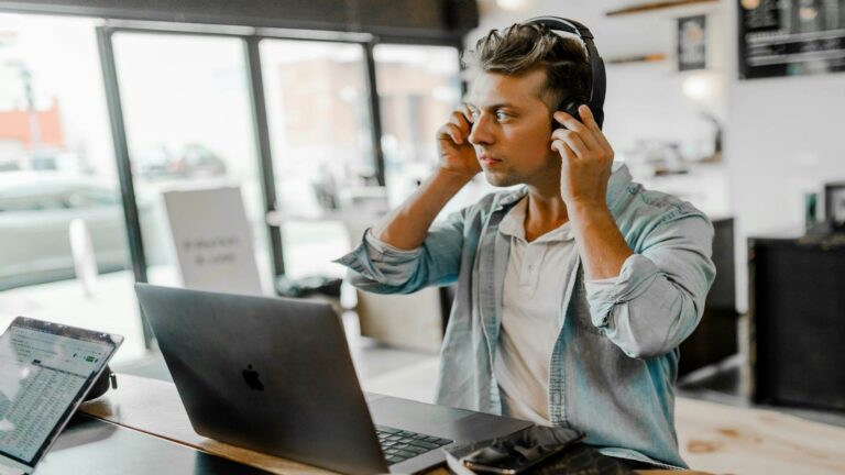 Web Design London expert working on a laptop with headphones in a creative workspace