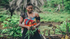 Woman practicing sustainable farming techniques in a lush green environment