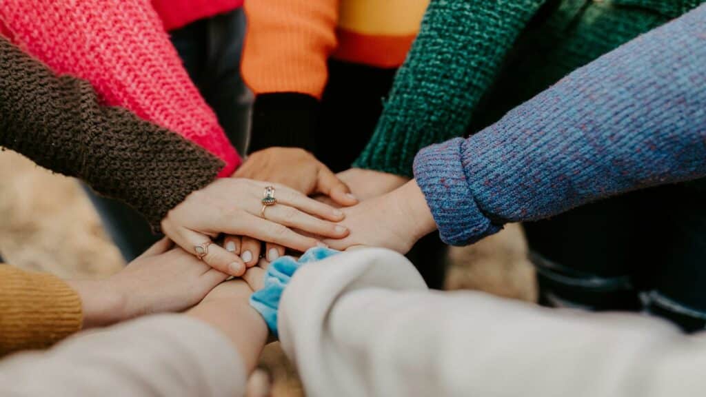 Hands joined together symbolizing teamwork in web design examples