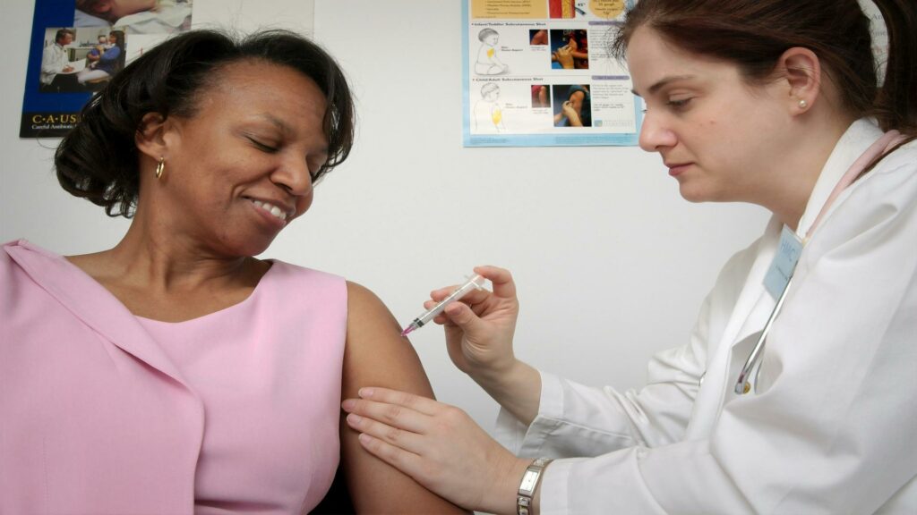 Healthcare professional administering a vaccine to a patient - Website design company