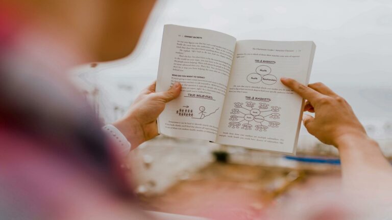 Person reading a book on online marketing tools and strategies for web design in London