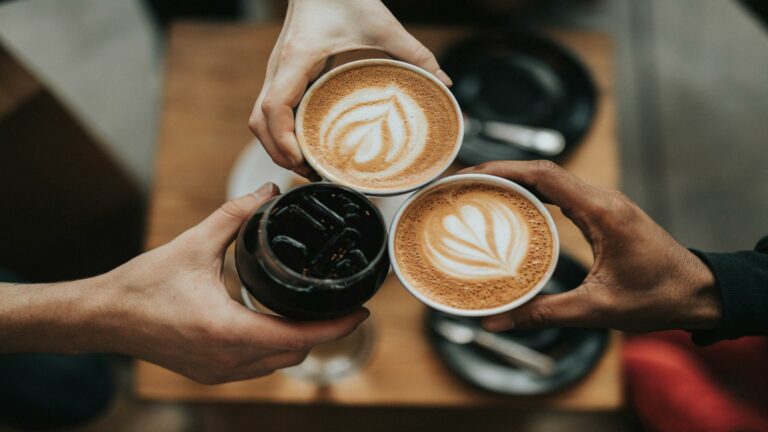 Coffee cups with latte art and iced coffee representing creative collaboration in web design examples