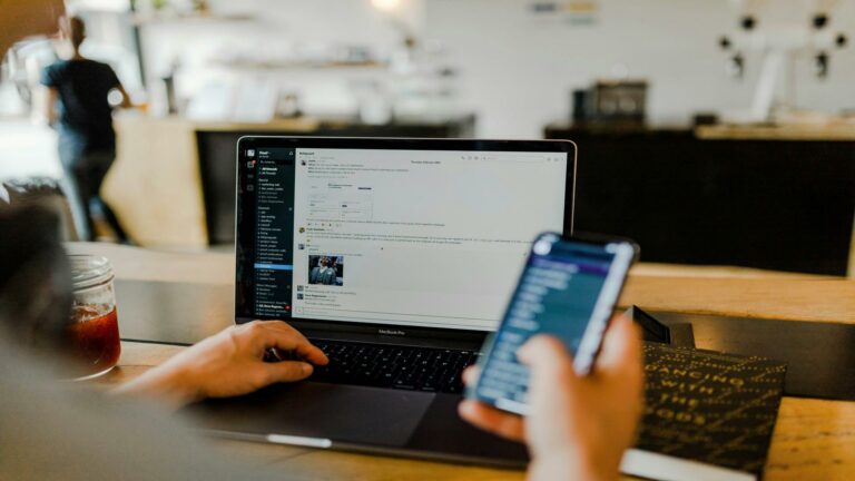 Person using a laptop and smartphone for digital communication to build customer relationships