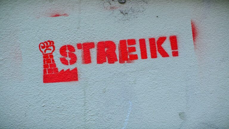 Red graffiti with the word 'Streik' and a raised fist symbolizing strike action