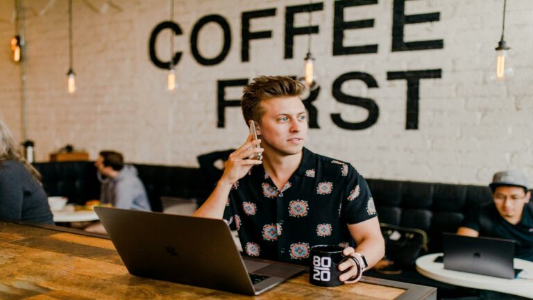 Person working on a laptop while holding a coffee mug, emphasizing building customer relationships