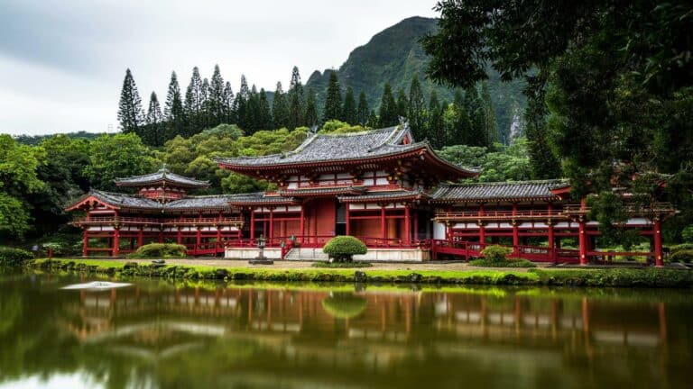 A traditional Japanese temple surrounded by lush greenery, reflecting in a tranquil pond, ideal for search engine optimization.