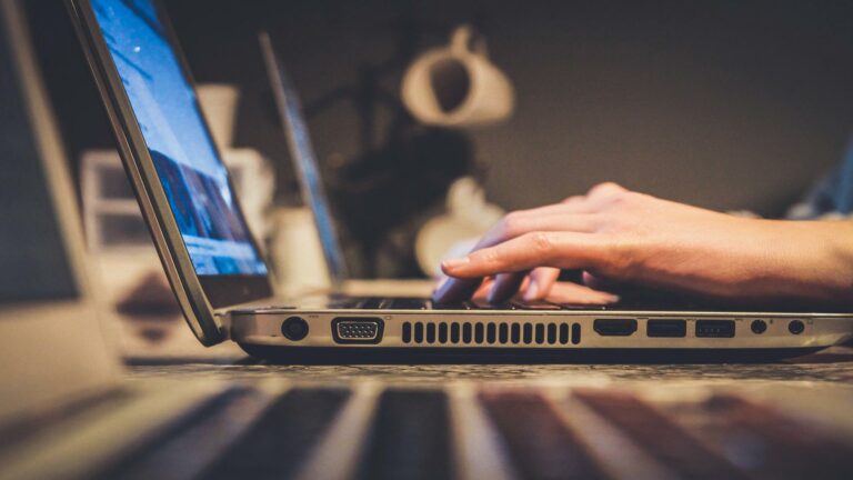 Hands typing on a laptop keyboard at a web design agency in London