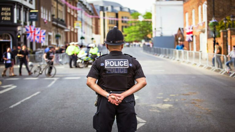 Website optimization services demonstrated through police officer monitoring street safety during UK celebration with Union Jack flags