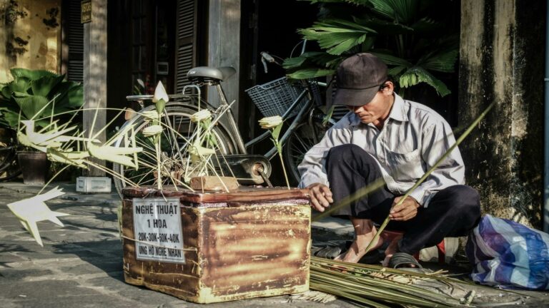 Man creating handcrafted flowers as part of traditional Vietnamese art, showcasing content marketing tools in cultural storytelling.