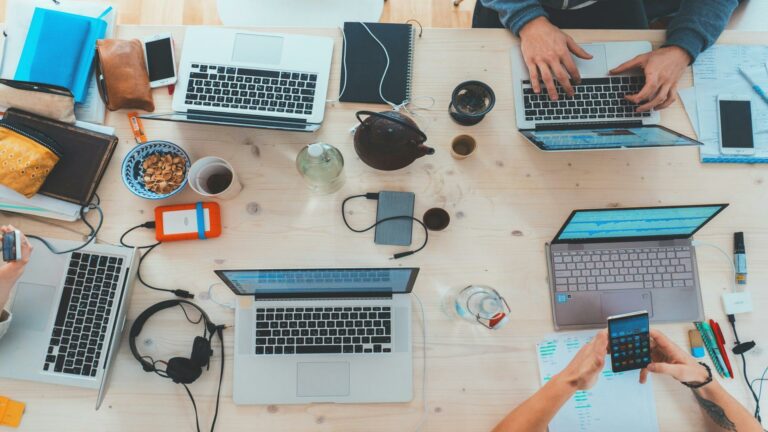 Overhead view of a collaborative workspace with laptops and gadgets, representing online marketing ideas