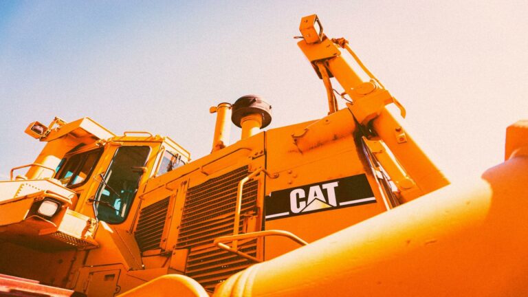 Yellow CAT construction equipment under a bright sky