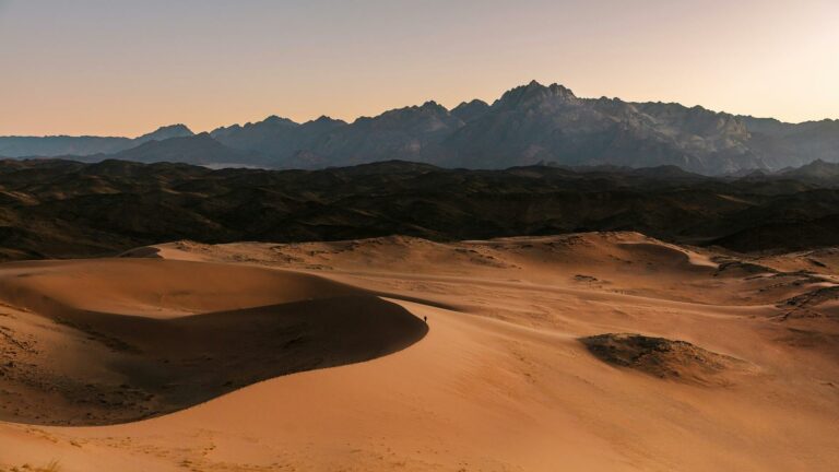 Breathtaking desert landscape with sand dunes and mountain range at sunset, captured by Web Design London