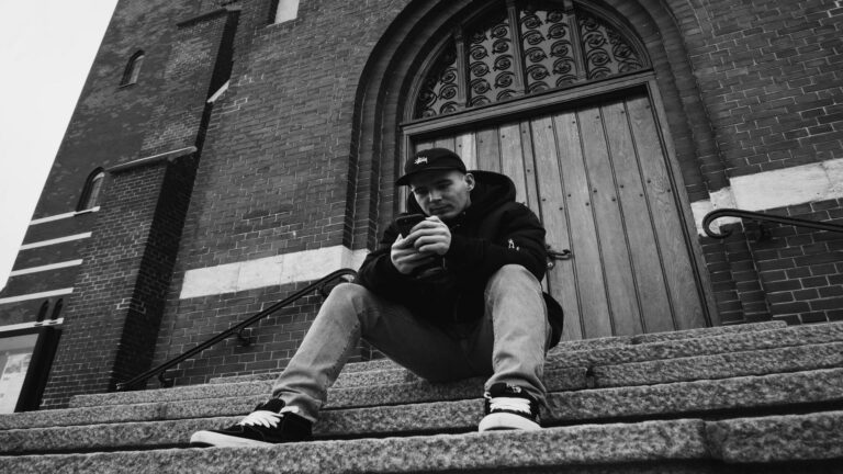 Person sitting on steps in front of a historic building in London, symbolizing Web Design London creativity