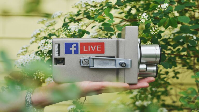 Hand holding a vintage camera with Facebook Live logo to build customer loyalty