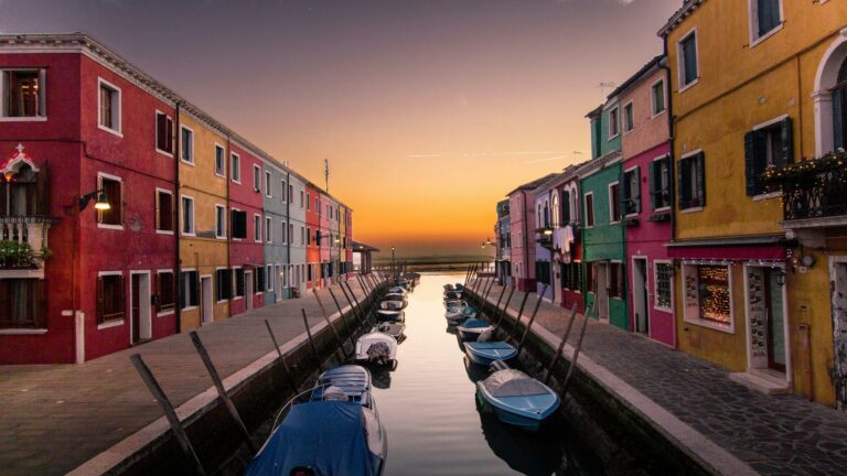 Colorful canal street at sunset with boats and vibrant buildings, ideal for search engine optimization