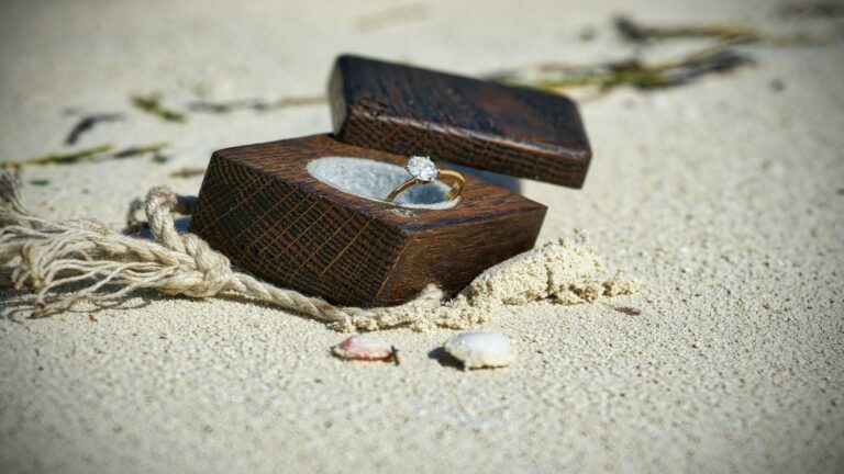 Engagement ring in a wooden box on a sandy beach - Effective content strategy