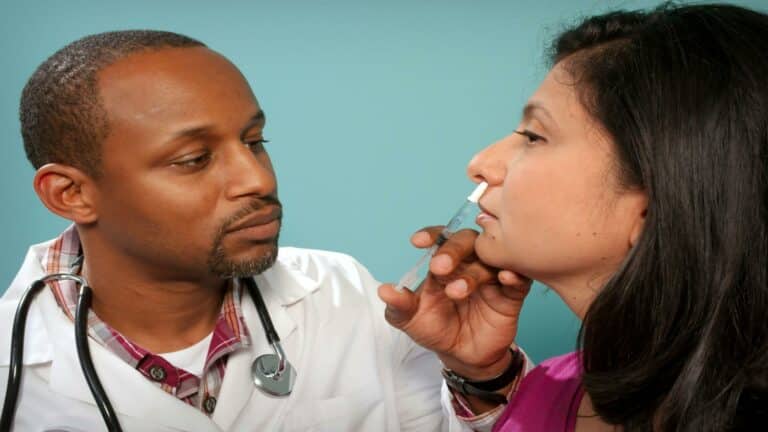 Doctor administering nasal spray to a patient - Website design company