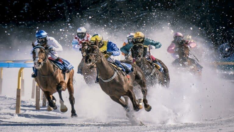 Horse racing on snow with jockeys competing in vibrant gear