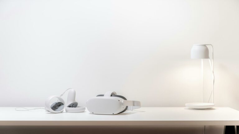 Website security tips with a virtual reality headset and controllers on a white desk next to a modern lamp