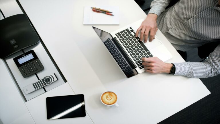 Modern workspace showcasing web design inspiration with a laptop, coffee, and office tools